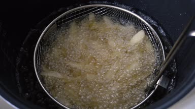 Patates kızartması derin yağda kızartılmış pişirilir. Kaynayan yağ. Çiğ patates par. hazırlanması.