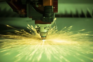 Otomatik programlanmış makine. Endüstriyel lazer makinesi çelik levha parçalarını kesiyor. Sıcaklık. Fabrikadaki üretim makinesinin çalışması sırasında kıvılcımlar.