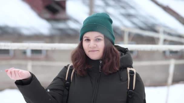 若い女性は雪の中で手で雪片をキャッチします. — ストック動画