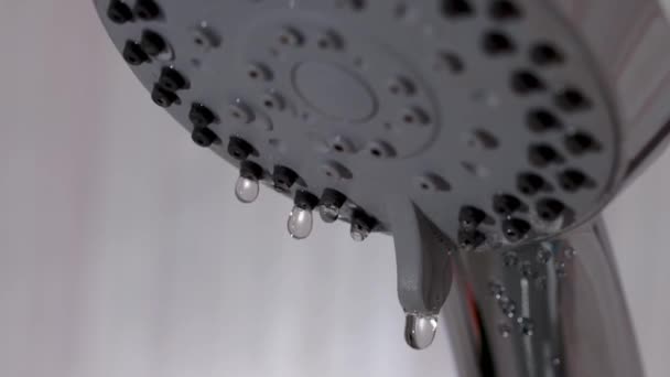 Er druipt water uit de douchekop. Druppelende druppels water in slow motion. — Stockvideo