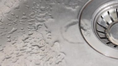Musluktan lavaboya su damlıyor. Su yavaş çekimde sıçrar..