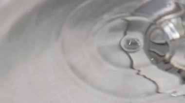 Musluktan lavaboya su damlıyor. Su yavaş çekimde sıçrar..