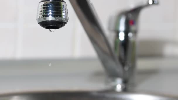 A víz csöpög a csapból a mosogatóba. A víz lassítva fröccsen.. — Stock videók