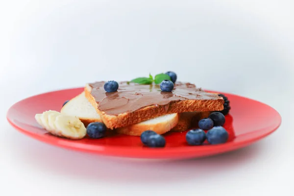 Toast with chocolate and nut paste and berry.