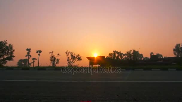 Transporte de camiones semirremolques que conducen por carretera ocupada en la hermosa puesta de sol de oro en verano. Salida del sol sobre la autopista . — Vídeos de Stock