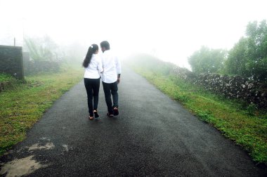 bir tepe üzerinde yürüme el ele tutuşarak romantik genç Çift