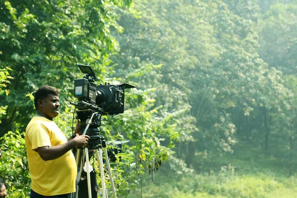 KODAIKANAL, ÍNDIA - JUNHO 21, 2016: Operador de câmera de vídeo no fundo da natureza, local de filmagem  . — Fotografia de Stock