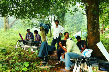Kodaikanal, Hindistan - 21 Haziran 2016: Happy friends çimenlerin üzerinde siting, çekim ve film yapma dostum iş küme