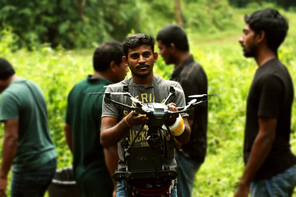 Кодайканал, Індія - 21 червня 2016: Молода людина з двох допомогу фотограф зйомки відео з керований по радіо quadcopter, молодий чоловік бере фото на літаючих віддаленого камери під час поїздки літо — стокове фото