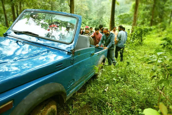 Kodaikanal, Indien - 29. Juni 2015: Menschen versuchen, das kaputte Auto in den Wald zu schieben . — Stockfoto