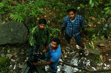 Kodaikanal, Hindistan - 29 Haziran 2015: Orada stand ile video kamera ile arayan kişi