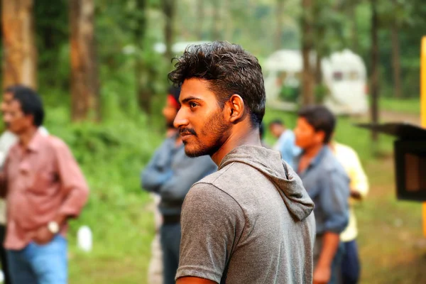 Kodaikanal, Hindistan - 29 Haziran 2015: yakışıklı genç adam dışında ve odak arka plan film ekibi dışında arıyorsunuz — Stok fotoğraf