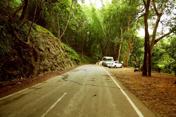 КОДАЙКАНАЛ, Индия - 29 ИЮНЯ 2015 г.: Парковка автомобилей съемочной группы на шоссе с природным фоном . — стоковое фото