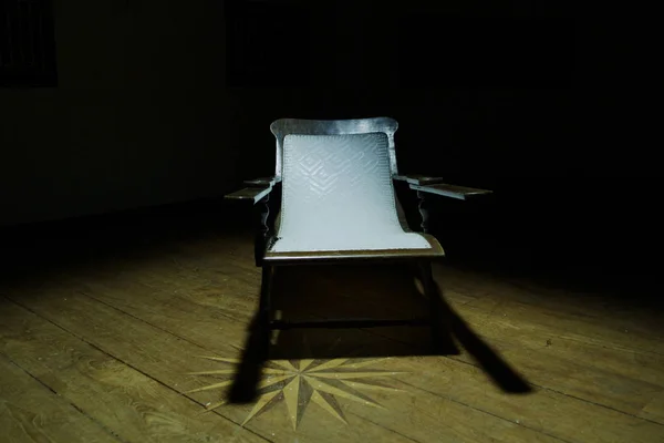 暗い部屋での木の古いレトロな椅子 1 つ、放棄された家の中の暗い部屋 — ストック写真