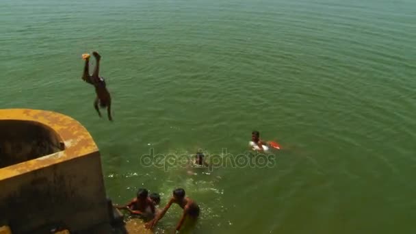 インド - 2016 年 3 月 18 日: トップレス白人男性を探して別の子供ながら川に岩からジャンプ — ストック動画