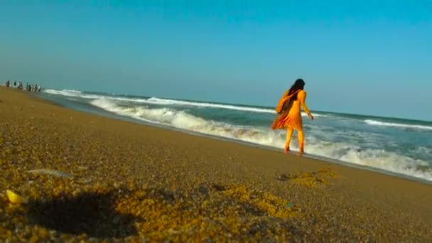 India - 17 maart 2016: Vrouw lopen en spelen op het strand water golven. — Stockvideo
