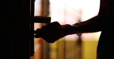 Genç güzel Bayan açık ev siluet kapıya vurdu.