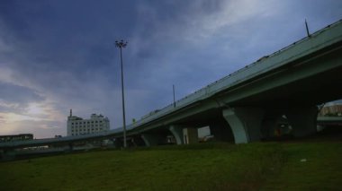 Chennai, Hindistan köprüsü üzerinde kara bulutlar yağmur taşıdıktan sonra köprüde, güneş doğuyor.