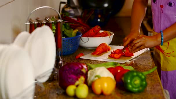 Mujer joven cortando verduras en la cocina — Vídeos de Stock