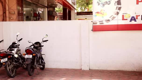 CHENNAI, INDIA - 26 DE OCTUBRE DE 2015: Mujer joven y niño estacionando una bicicleta en el estacionamiento de bicicletas — Vídeos de Stock