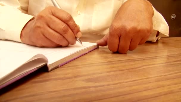 Close up old man writing notes in notebook. dolly shot — Stock Video