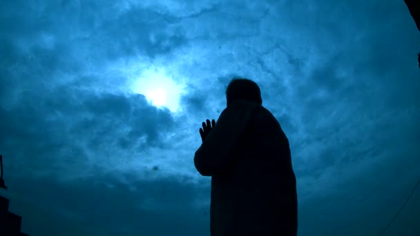 Silhouette senior man praying with blue sky — Stock Video