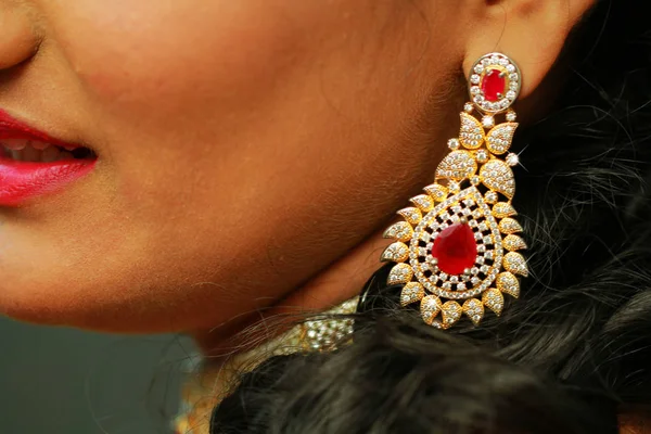 Närbild av vacker kvinna som bär glänsande gyllene diamantörhängen — Stockfoto