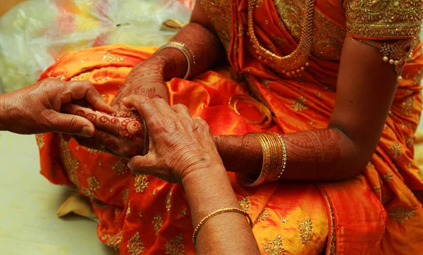 groom puts bangle in bride hand at bangle ceremony