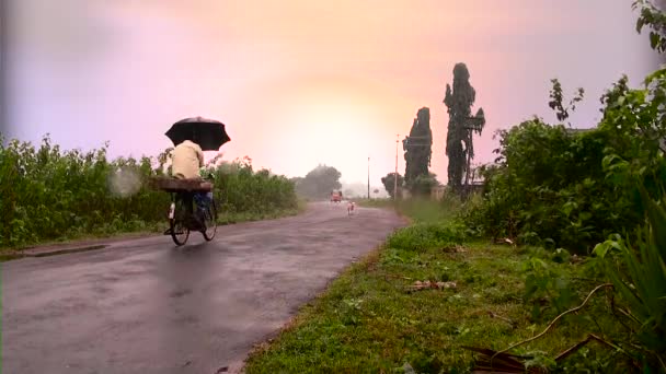 INDIA - MARCH 1, 2017: Indian rural road, passing on bicycle, Tuk-tuk auto rickshaw taxi coming towards camera. — Stock Video