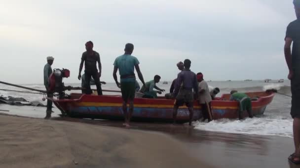 POOMPUHAR, Inde - 12 NOVEMBRE 2015 : Des pêcheurs indiens débarquent du poisson d'un bateau de pêche à quai - Zoom avant . — Video