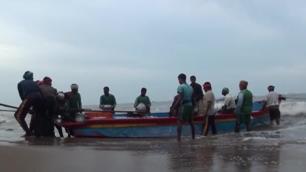 POOMPUHAR, India - 12 DE NOVIEMBRE DE 2015: Pescadores indios descargando pescado de un barco pesquero en el muelle . — Vídeo de stock