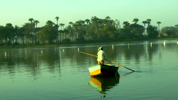 Indie - 12 březen 2016: lidé na lodi, plavby při západu slunce, mladí rybáři je plovoucí na jezeře. — Stock video