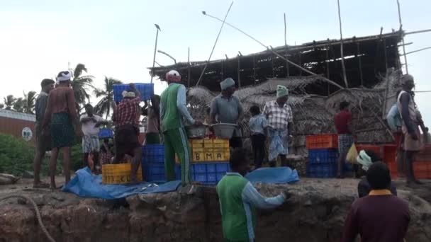 POOMPUHAR, INDIA - 12 DE NOVIEMBRE DE 2015: Los pescadores sacan cestas de pescado del barco y las clasifican en cajas . — Vídeos de Stock