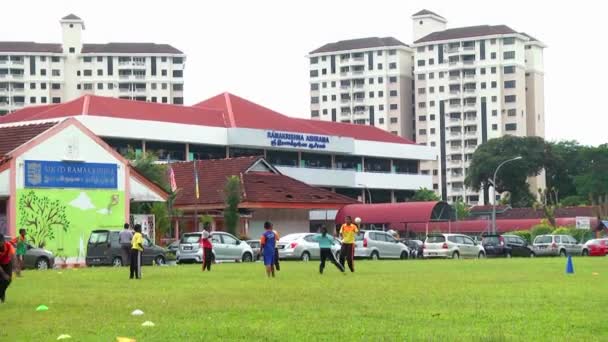 Malaysia - 02 juli 2016: Barn spelar fotboll i en idrottsplats. — Stockvideo