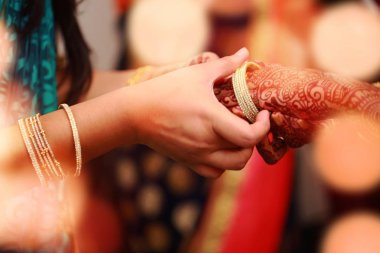 damat gelin el ışıklar ile bileklik töreninde bileklik koyar.