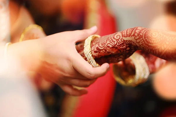 Brudgummen sätter armring i bruden hand vid armring ceremoni med lampor. — Stockfoto