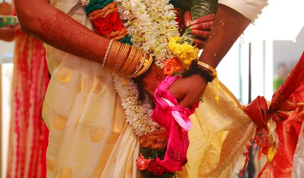 Close up das mãos do casal indiano em um casamento, noivo mantém a mão da noiva na cerimônia de casamento — Fotografia de Stock