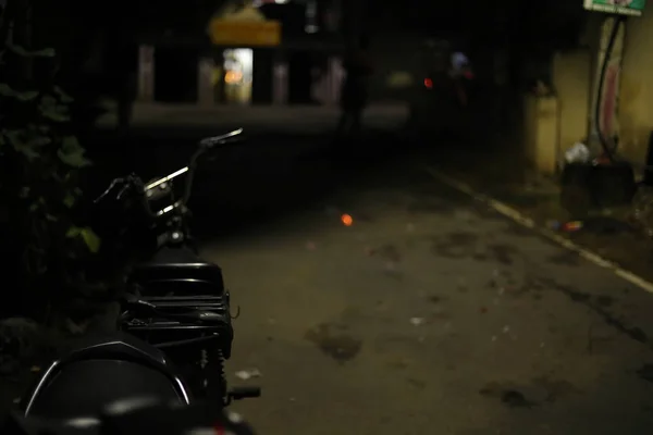 Noche de ciudad con bicicleta aparcada en un pequeño carril y zonas independientes — Foto de Stock