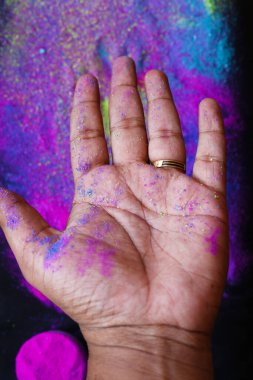 Çok renkli Holi pudralı, bulanık arka planlı el görüşü. Holi 'nin parlak renkleri