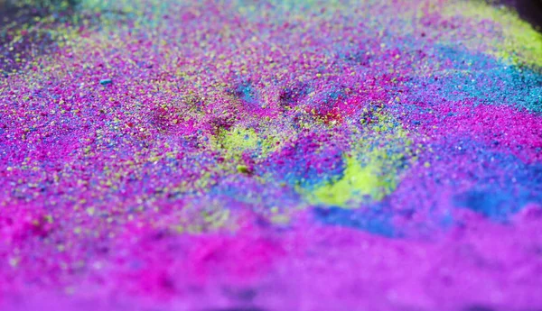 Abstract multicolored powder splatted on black background.