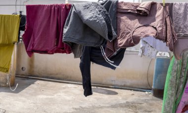 Temiz giysiler kuru kalsın diye asılmış. Ev aktivitesi, çamaşır..