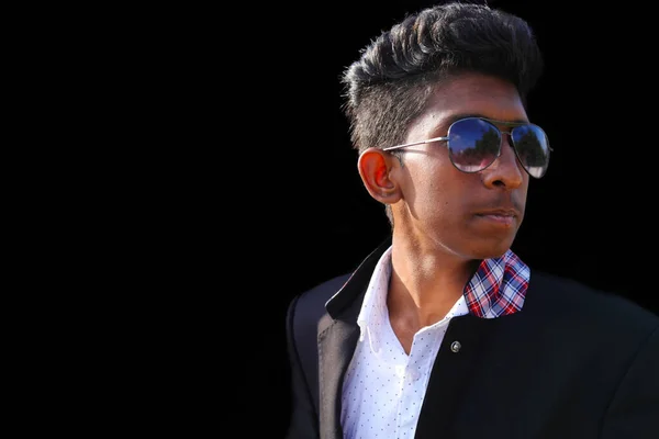 Indian cool young hipster man in a fashionable jacket in stylish sunglasses with trendy hairstyle