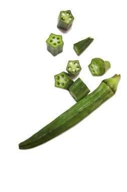 Taze bamya ya ya da beyaz arka planda izole edilmiş kadın parmakları.