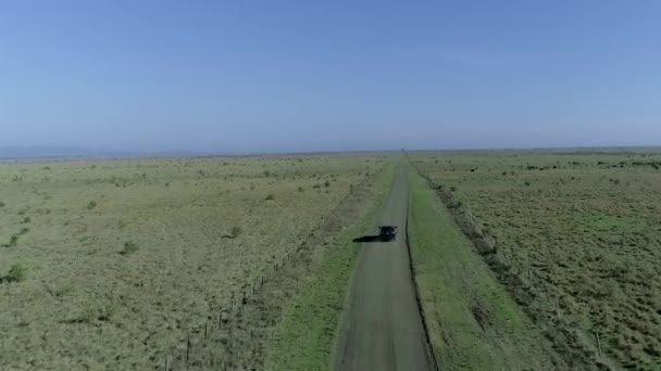 Letecký pohled na auto jízdy na venkově silnici přes modré nebe — Stock video