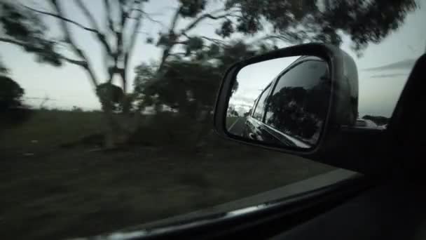 Jazda po wiejskiej drodze z widokiem na boczne lusterko w dzień. Punkt widzenia kierowcy patrzący przez lusterko boczne. Melbourne, Australia. — Wideo stockowe