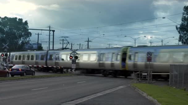 Austrália - FEVEREIRO 02, 2020: carros esperando na travessia ferroviária em passes de trem, passes de trem de passageiros — Vídeo de Stock