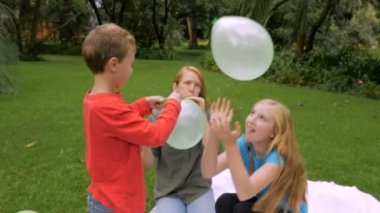 İki genç çocuk başlatmak bir balon çevresinde aile ile - slowmo isabet