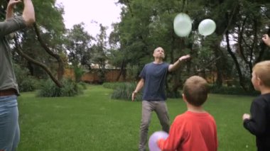 Beş kişilik bir aile var bir gün parkta birlikte balonlarla - slowmo oynama
