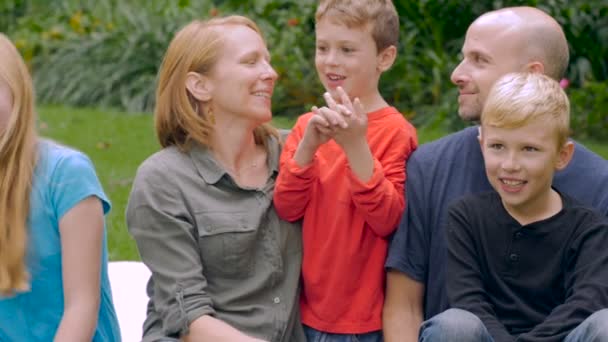 Uma família caucasiana de cinco sorrisos e ouvir o seu filho mais novo falar-slowmo — Vídeo de Stock
