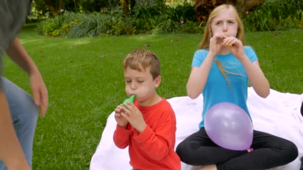 Eine Mutter kommt, um ihrem jüngsten Sohn zu helfen, Luftballons aufzublasen - slowmo steadicam — Stockvideo